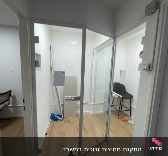 דלת זכוכית עם ידית לבנה בחדר משרדי